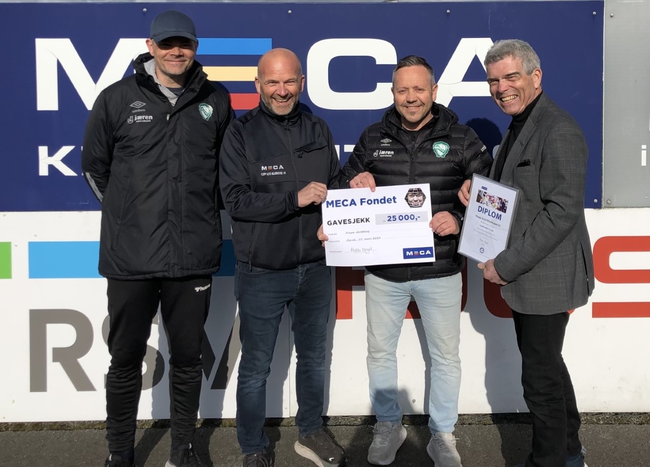 Fire menn holder MECA Fondets gavesjekk på 25 000.- og diplom foran MECA-skilt.