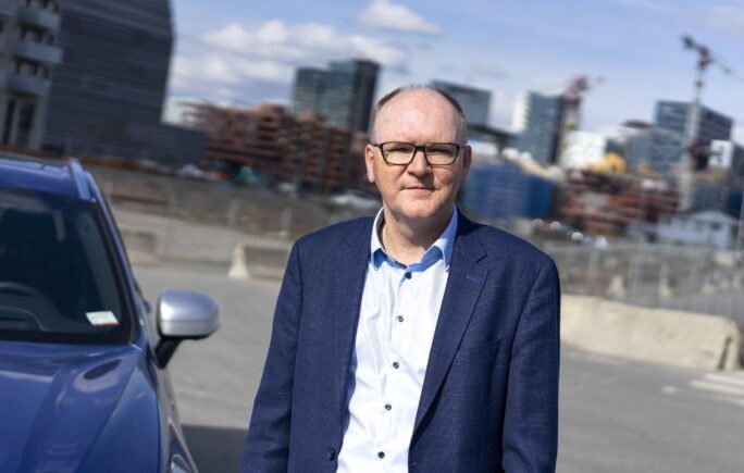 Voken mann i blå dress på en parkeringsplass