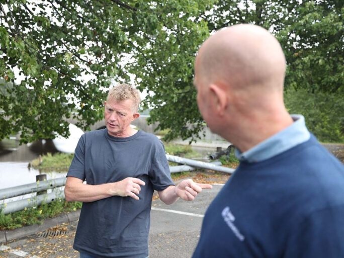 To menn prater sammen på parkerinsplassen