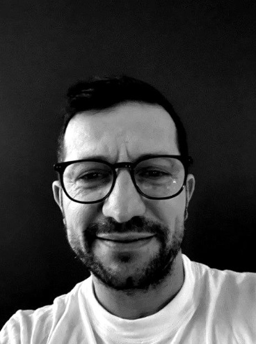 Profilbilde i sort/hvitt av en yngre mann med briller og mørkt hår