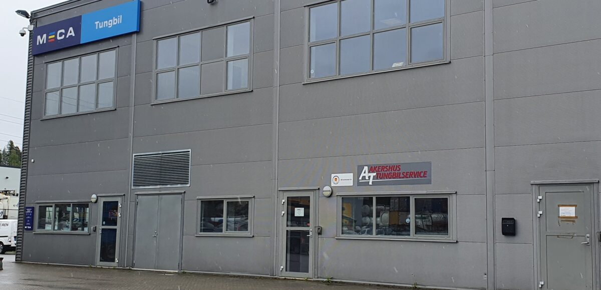 Grå bygning med skilt for MECA Tungbil og Akershus Tungbilservice.