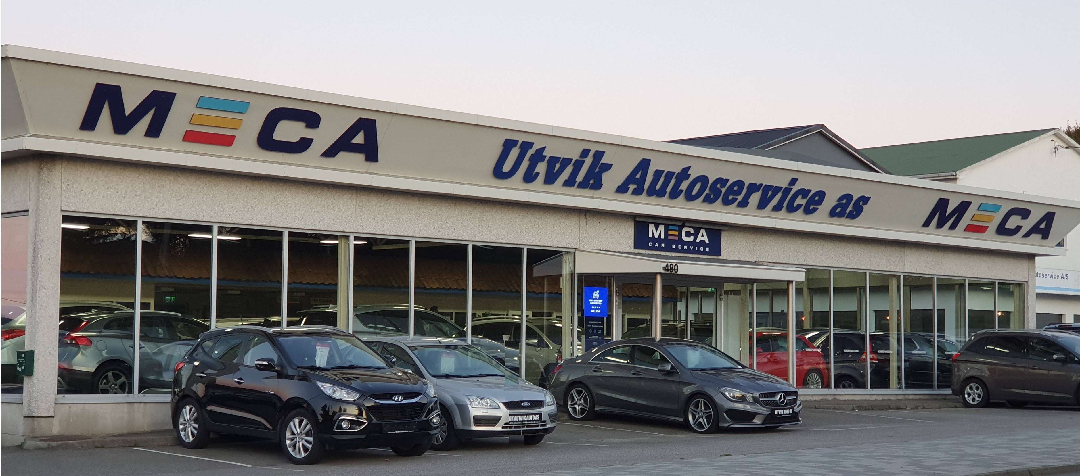 Bilverksted med tre biler parkert foran, skiltet "Utvik Autoservice AS" vises tydelig.