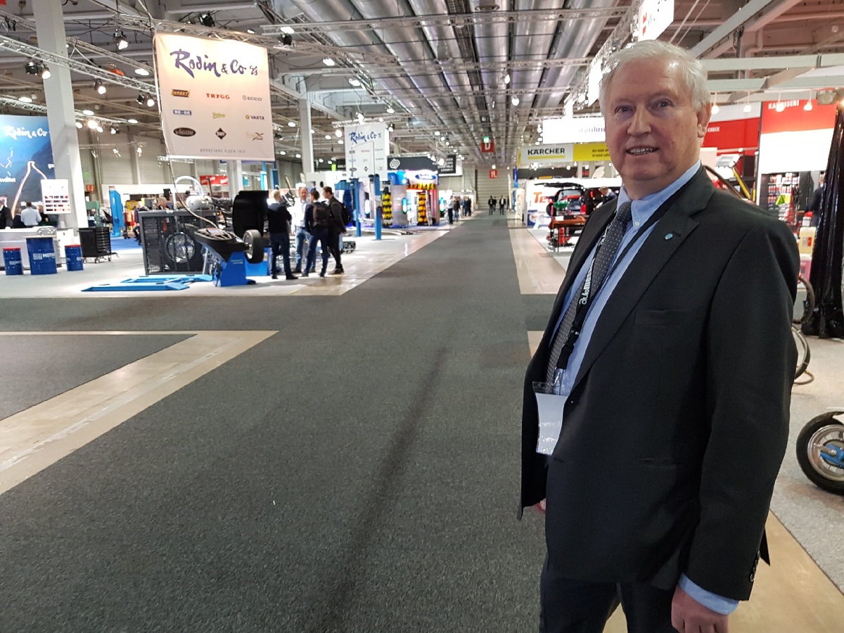 Voken mann i dress inne i en stor messehall