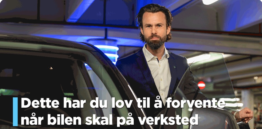 Mann med mørke hår og skjegg stå i døråpningen på en bil inne i en utstillingshall