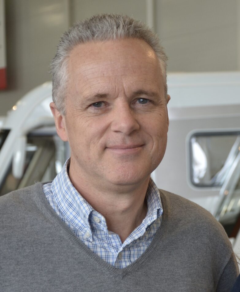 Profilbilde av mann med skjoret og brun genser