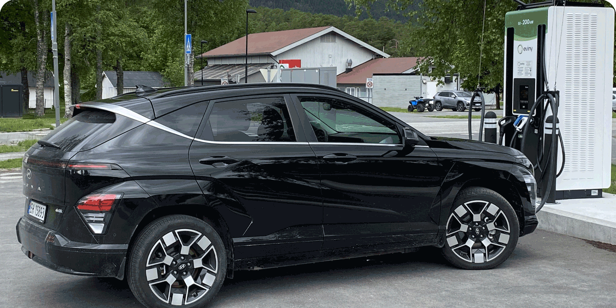 Plakat av en sort elbil på lading, med teksten Slik får du en bedre Elbil-ferie