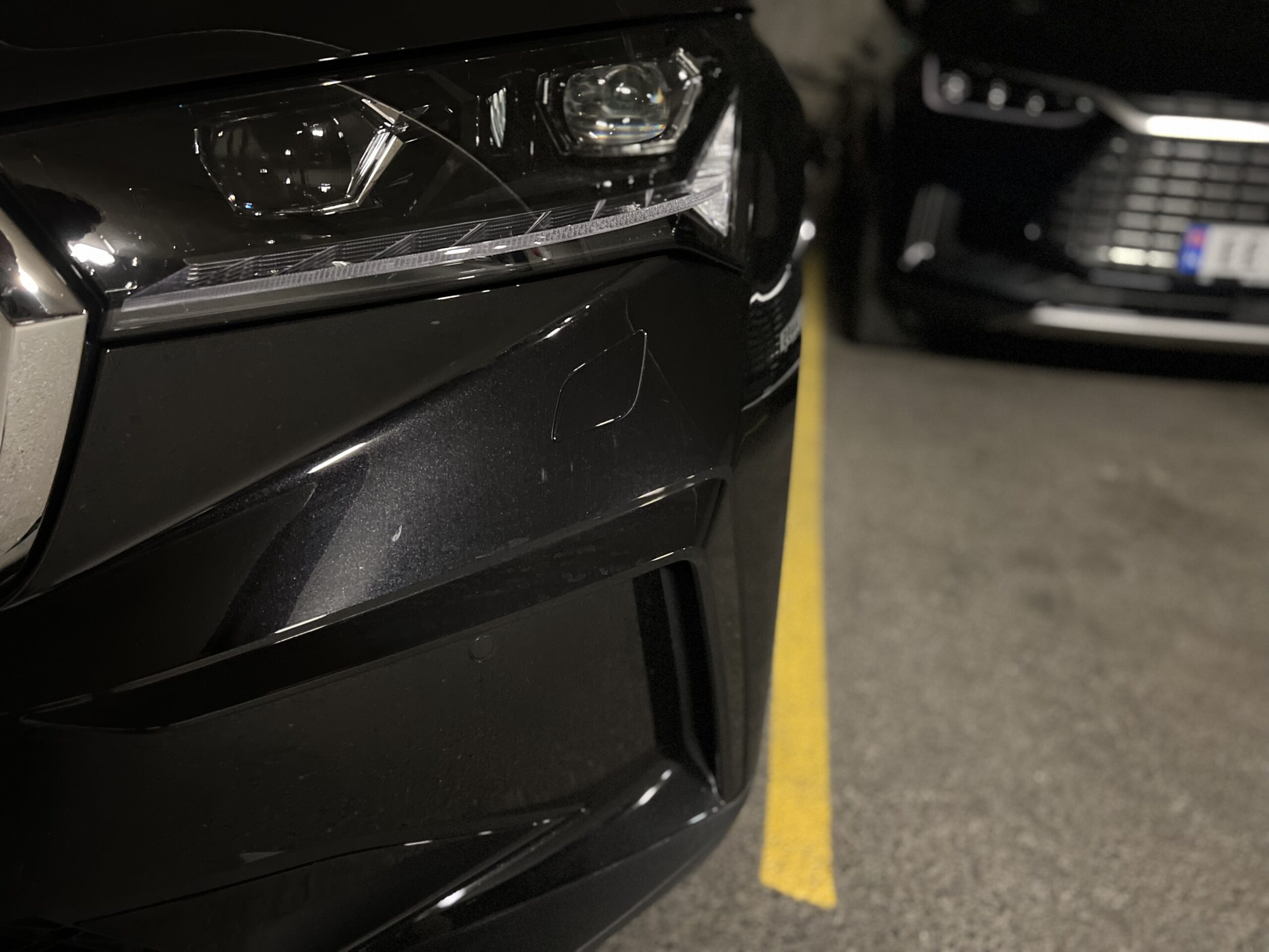 Hjørnet på en svart bil i parkeringshus