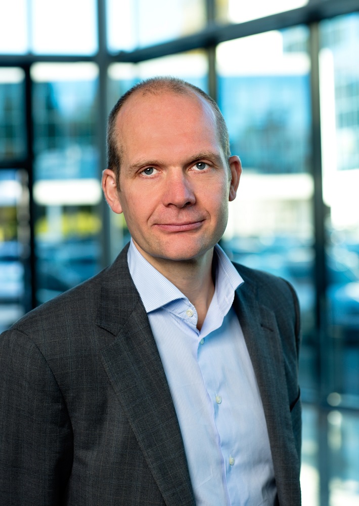 Profilbilde av voken mann med sort dress og blå skjorte