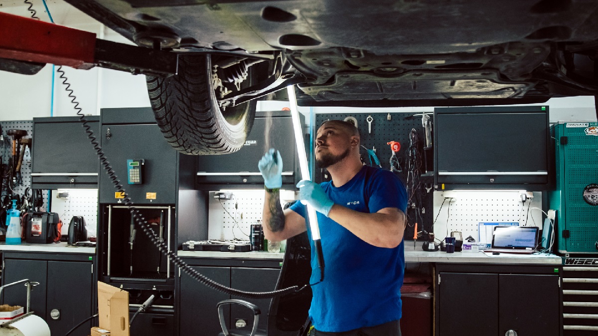 EU-kontroll - mekaniker sjekker under bilen, om bilen blir EU-godkjent