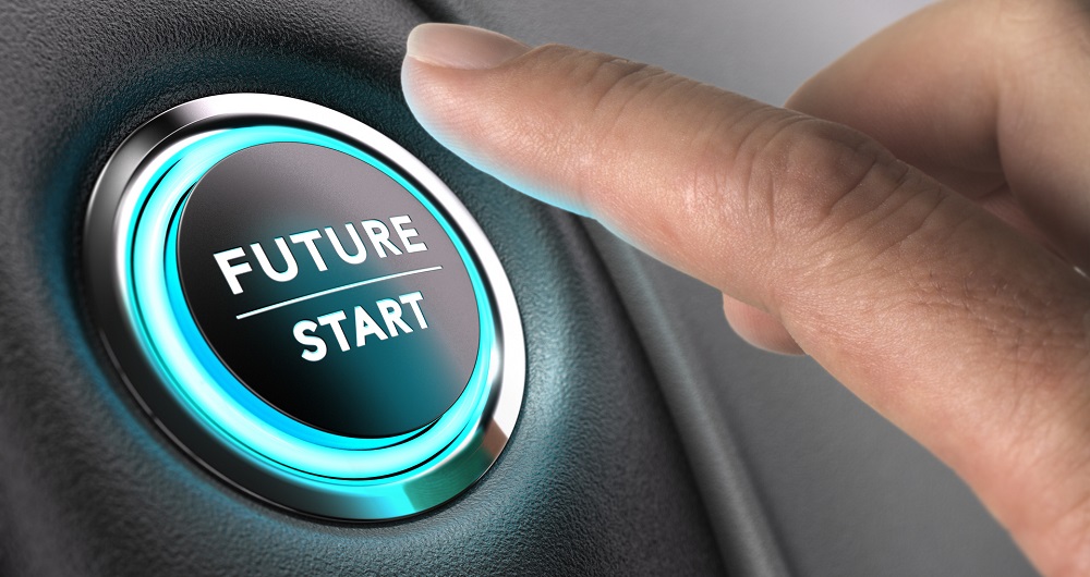 Jobb i et miljøvennlig selskap Finger about to press future button with blue light over black and grey background. Concept image for illustration of change or strategic vision.