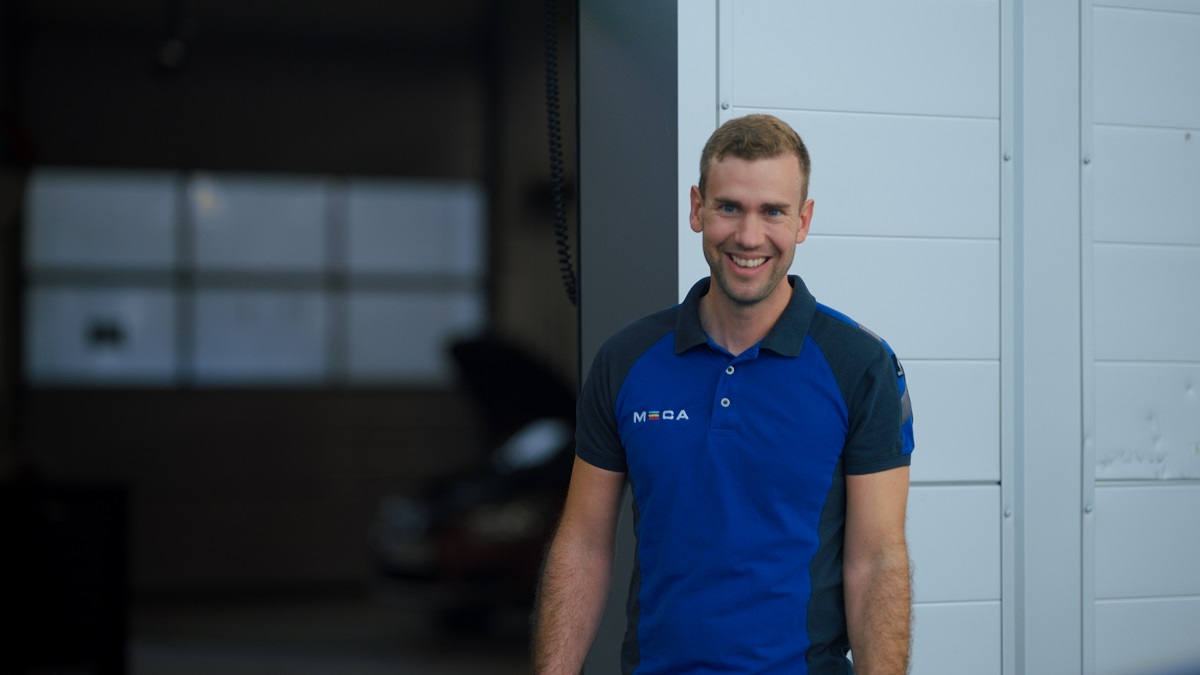 Mekaniker i MECAblå t-shirt, utenfor verkstedet