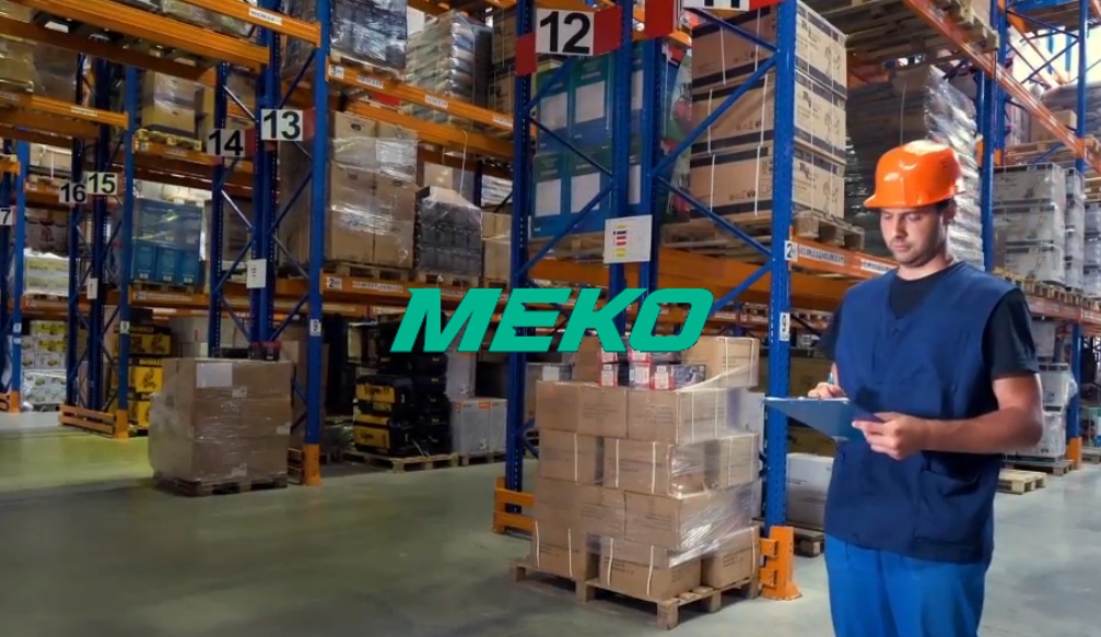 Lageransatt med blå klær og oransje hjelm plukker bildeler på et MEKO grossistlager 