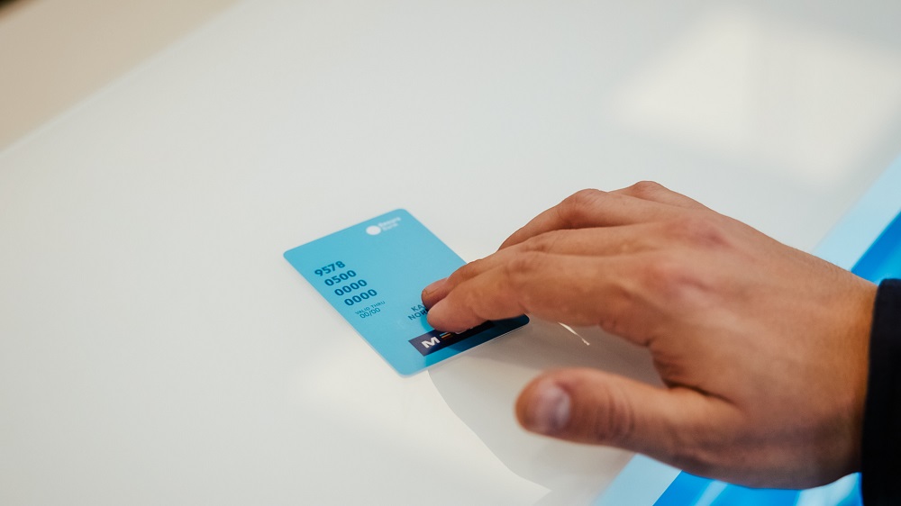 MECA kortet, som er en betalingsløsning fra Resurs bank, blir skjøvet fremover en hvit disk av en manns hånd
