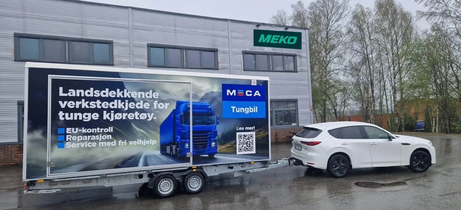 MECA Tungbil tilhengeren bak en hvit personbil foran ett grått MEKO lagerbygg