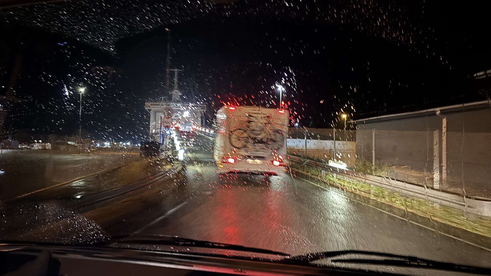 Bobiler i ferjekø en mørk, regnfull kveld