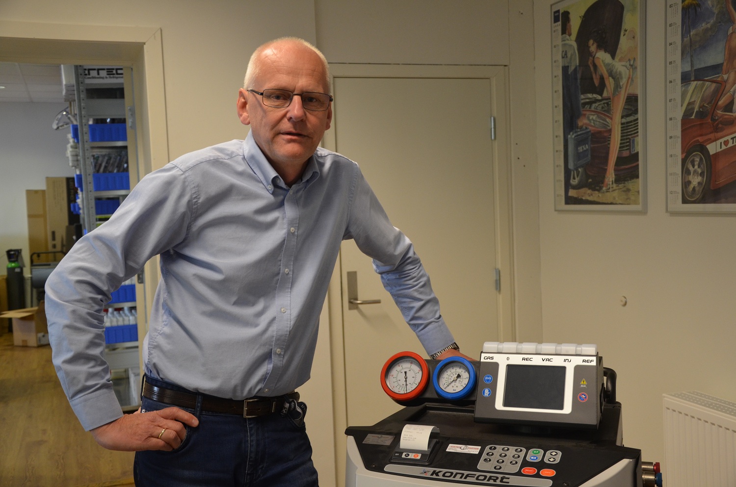 Voksen mann med lysblå skjorte, står ved måleinstrument for AC