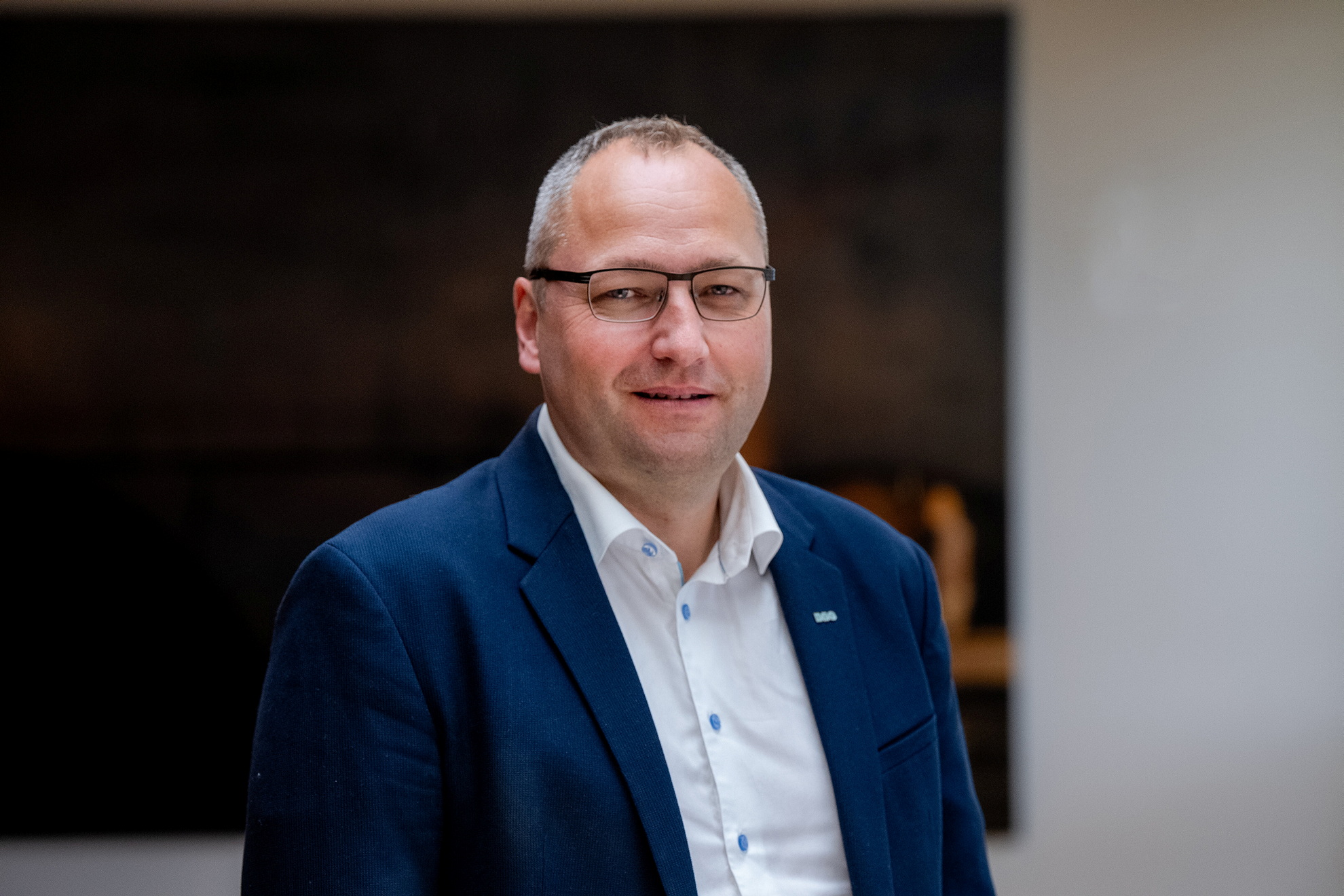 Profilbilde av mann med briller blå dress og hvit skjorte