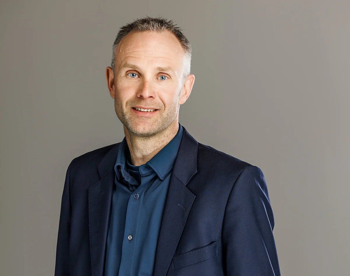 Profilbilde av mann med blå dress og blå skjorte