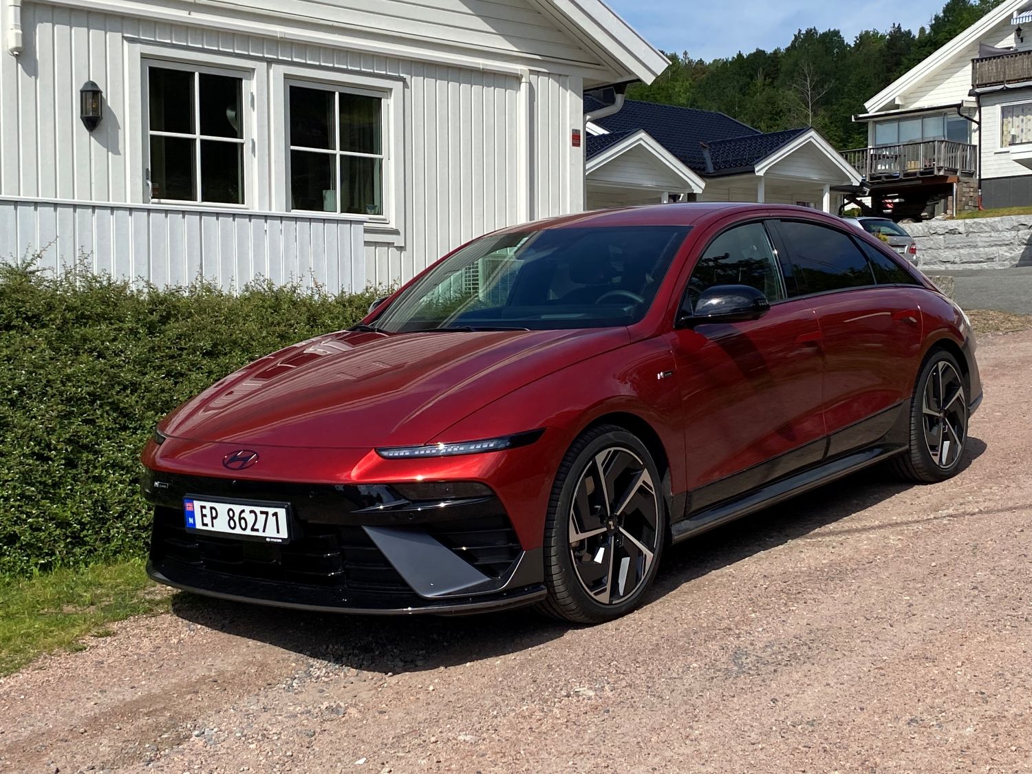 Rød Hyundai Ioniq 6 N Line parkert foren et hvitt hus