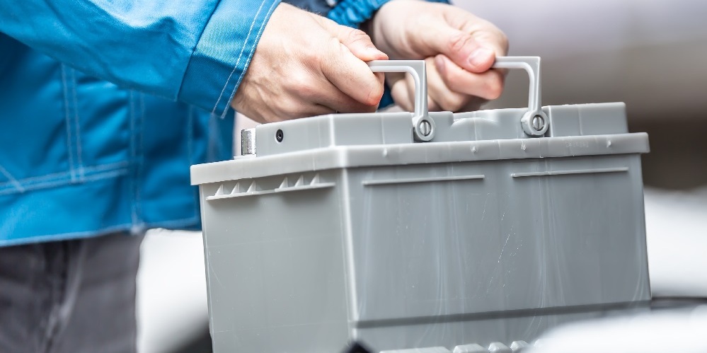 Mekaniker som flytter på et bilbatteri